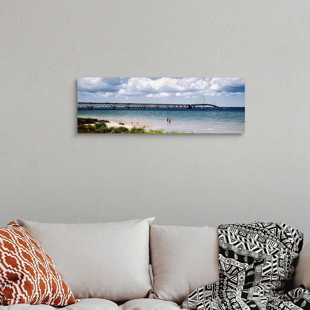 A bohemian room featuring Panoramic picture of a massive bridge that stretches across a lake in Michigan. Some beach on the...