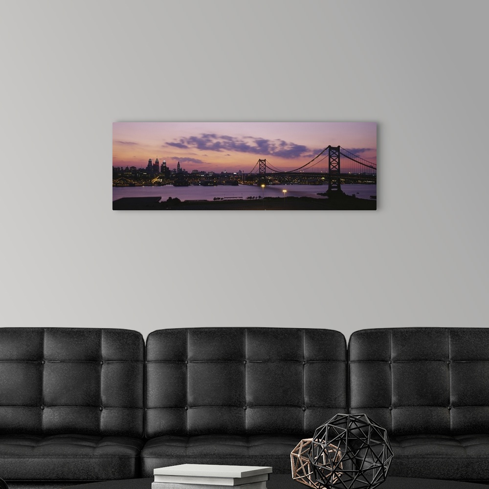 A modern room featuring Panoramic photograph of city skyline and overpass at dusk.  The sun is setting, the sky is cloudy...