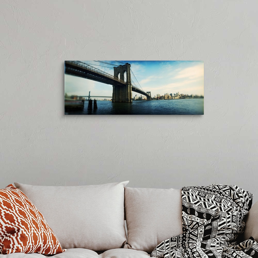 A bohemian room featuring This elongated piece is a photograph taken of the Brooklyn Bridge from the Manhattan side.