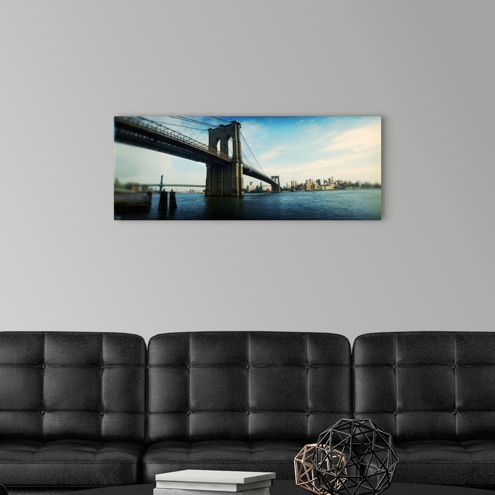 A modern room featuring This elongated piece is a photograph taken of the Brooklyn Bridge from the Manhattan side.