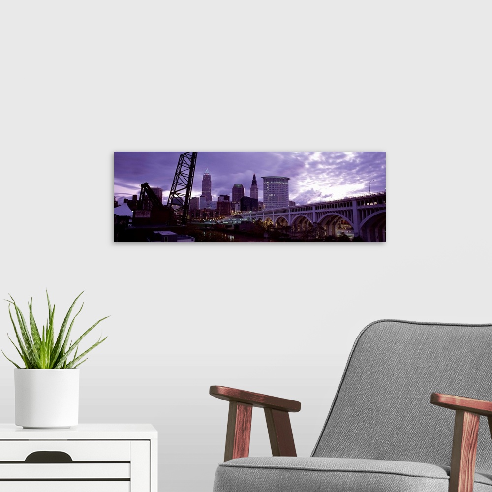 A modern room featuring Big panoramic piece of the Detroit Avenue bridge and the skyline shown in the background. Grey cl...