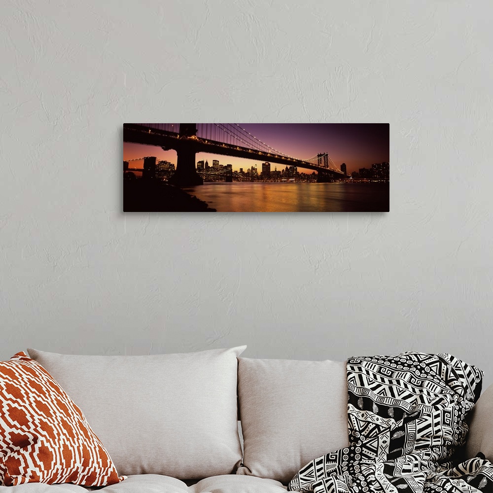 A bohemian room featuring Panoramic photograph of overpass crossing body of water, connecting two cities at sunset.  The ci...