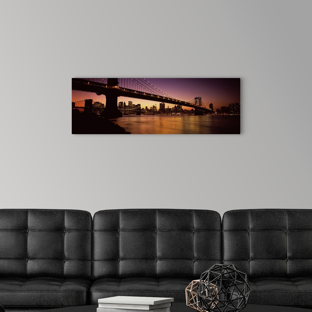 A modern room featuring Panoramic photograph of overpass crossing body of water, connecting two cities at sunset.  The ci...