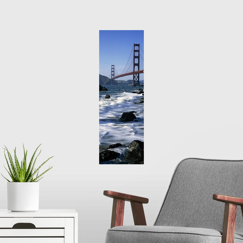 A modern room featuring Vertical photograph on a big canvas of the water crashing into the rocks along the shore of Baker...