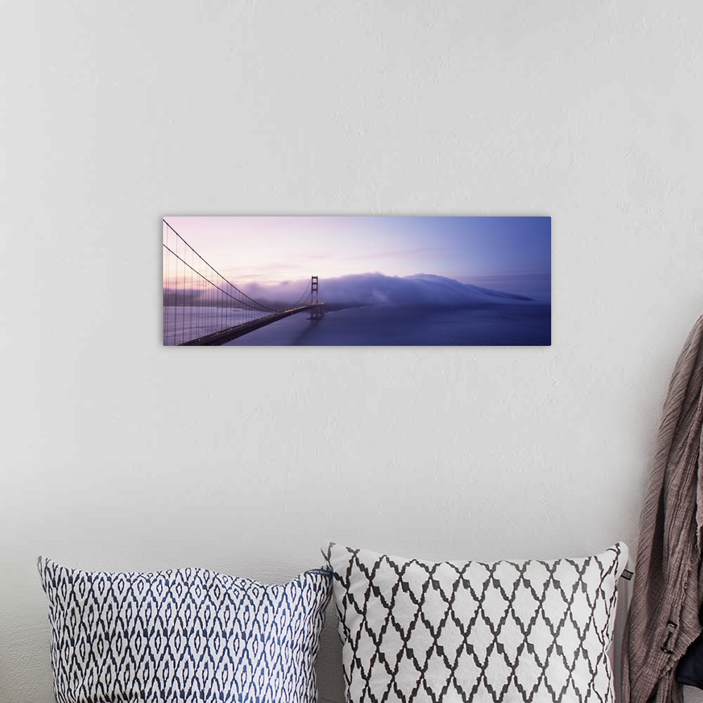 A bohemian room featuring Panoramic photograph of overpass crossing ocean and disappearing into fog.