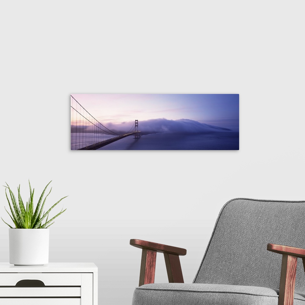 A modern room featuring Panoramic photograph of overpass crossing ocean and disappearing into fog.