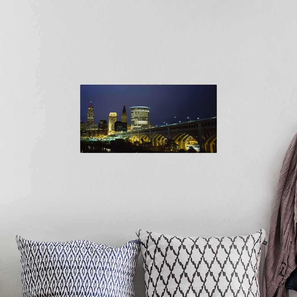 A bohemian room featuring Panoramic photograph of overpass leading to a lit up collage of buildings at dusk.