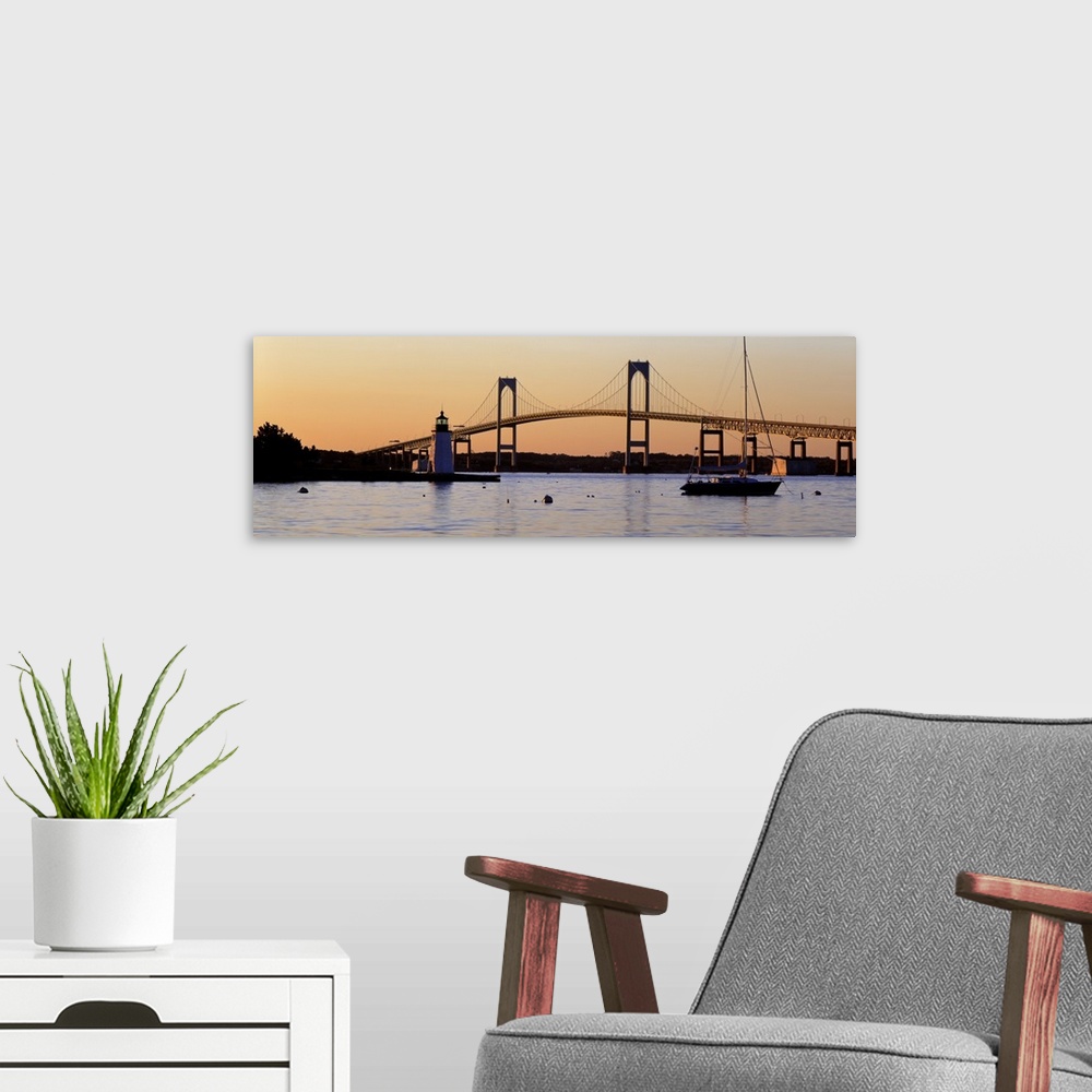 A modern room featuring Panoramic photograph of overpass in New York with lighthouse and boat in front of it at sunset.