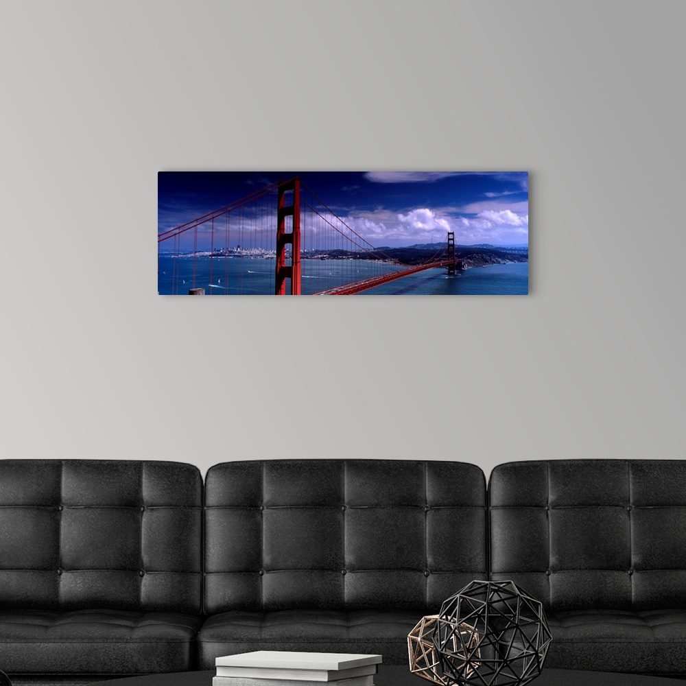 A modern room featuring Panoramic photograph of the suspension bridge over the mouth of the bay on a sunny day as clouds ...