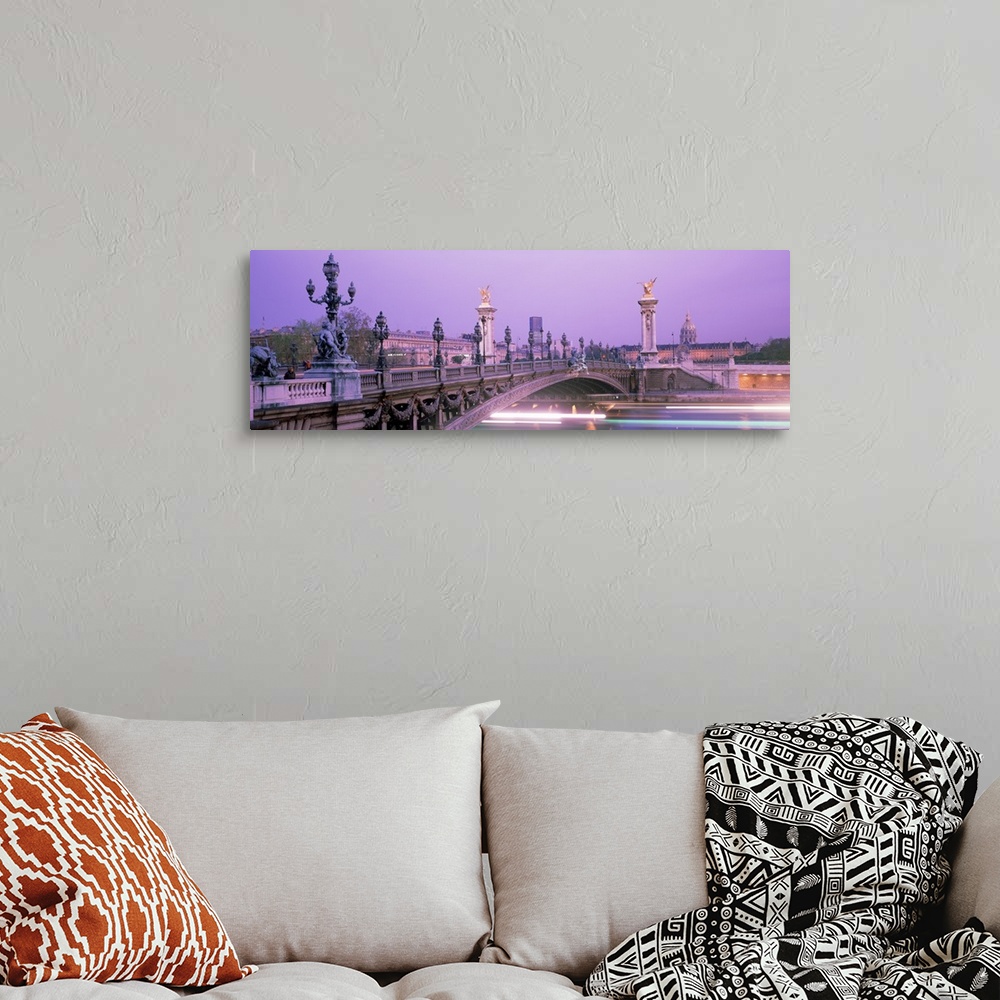 A bohemian room featuring This panoramic photograph is a time lapsed photo that captures streaks of lights of boats passing...