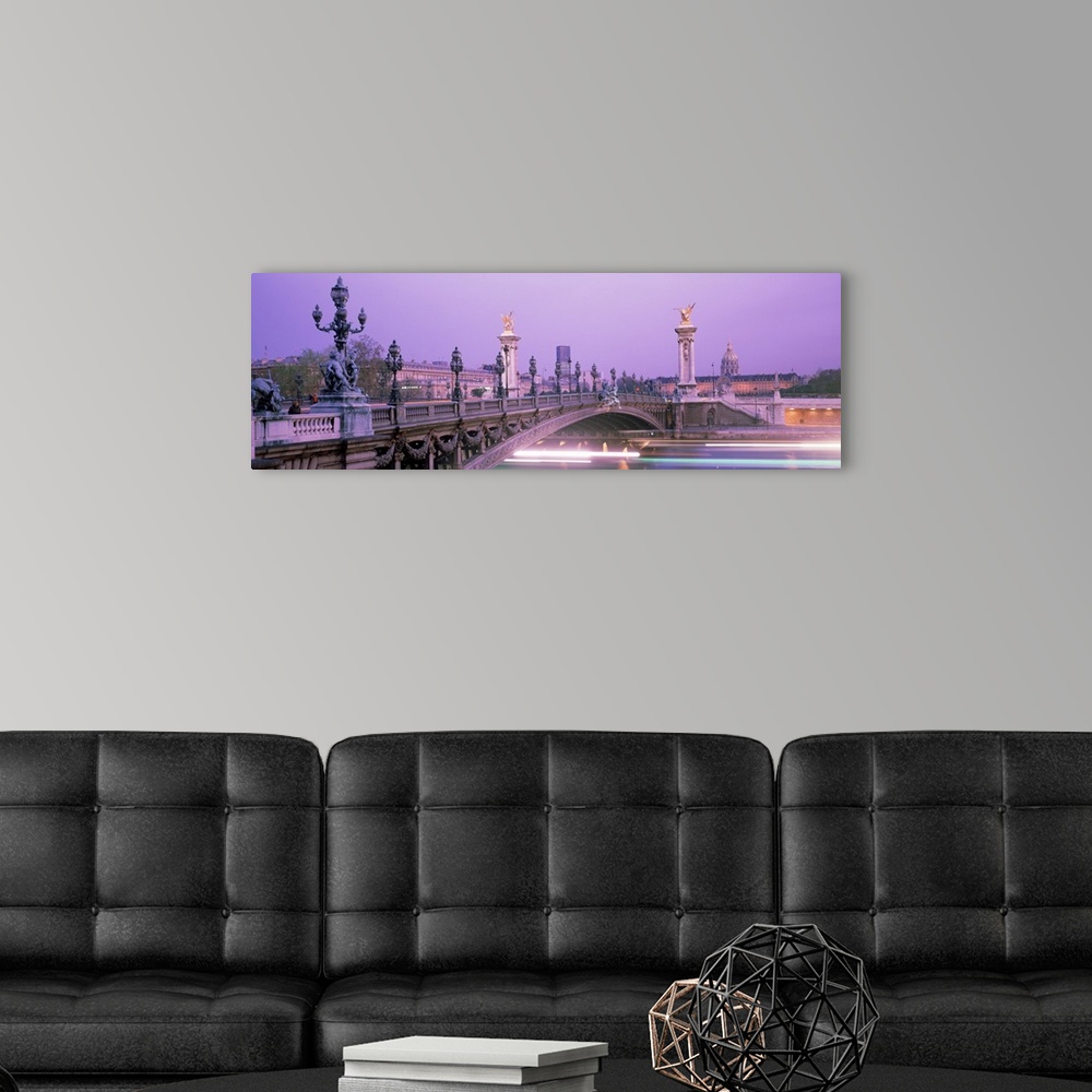 A modern room featuring This panoramic photograph is a time lapsed photo that captures streaks of lights of boats passing...