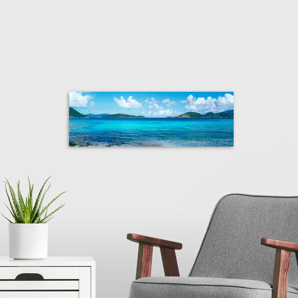 A modern room featuring This wall art for the home or office is a panoramic photograph of a tropical beach surrounded by ...