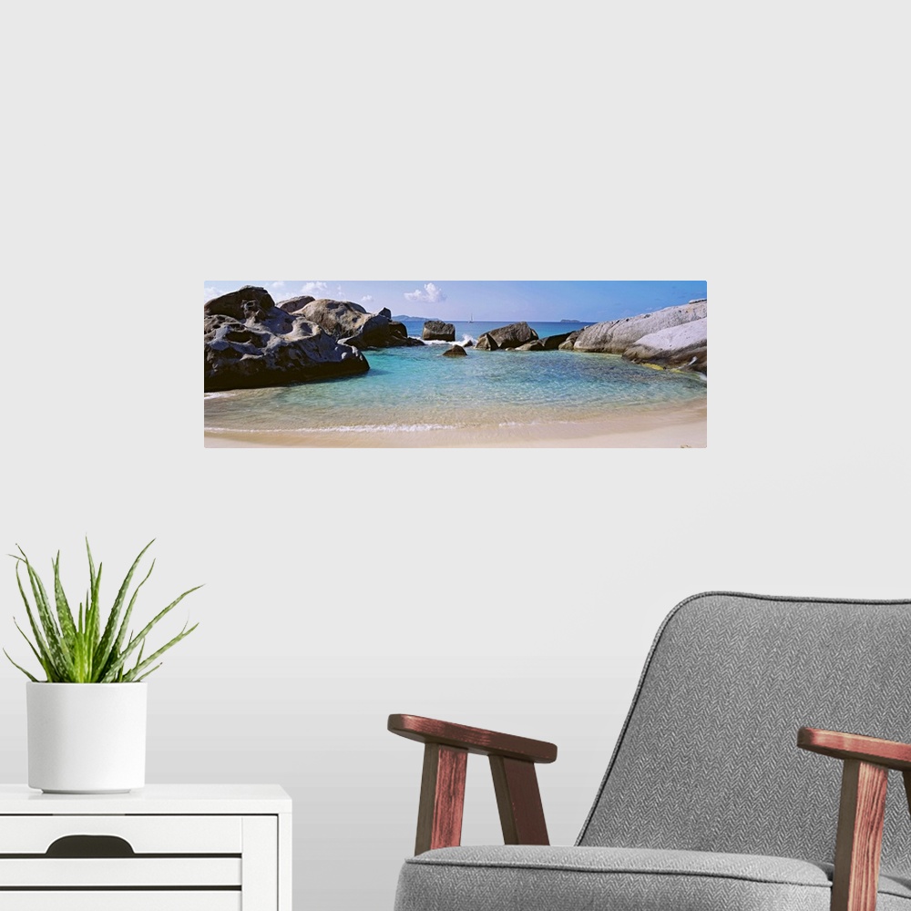 A modern room featuring Panoramic photograph showcases an ocean traveling into a small cove surrounded by large formation...