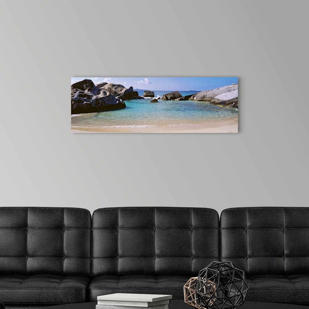 A modern room featuring Panoramic photograph showcases an ocean traveling into a small cove surrounded by large formation...