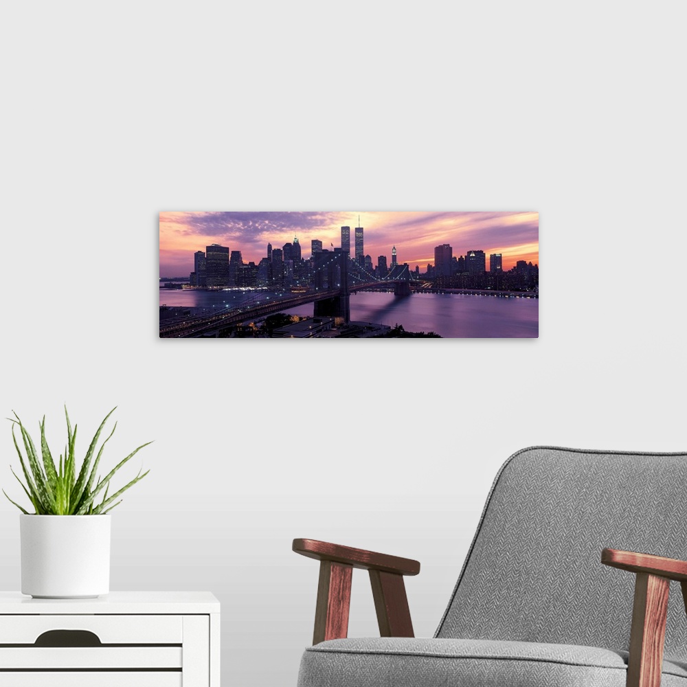 A modern room featuring This wall hanging is a panoramic photograph captures the fading sun as skyscrapers begin to turn ...
