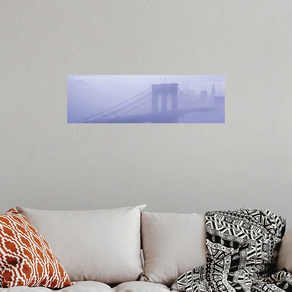 A bohemian room featuring Panoramic photograph on a giant wall hanging of fog surrounding New York's famous Brooklyn Bridge...