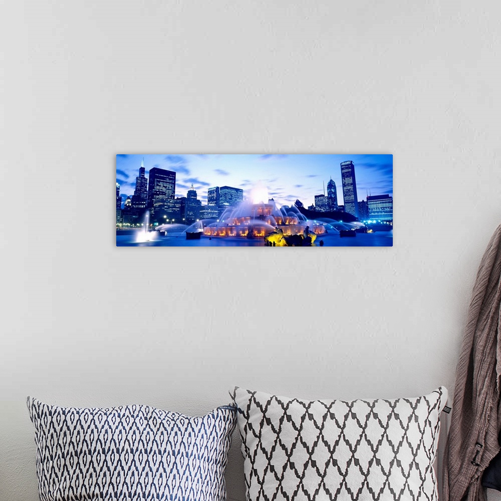 A bohemian room featuring A panoramic photograph of city skyline in the distance framing the fountain in the evening light.