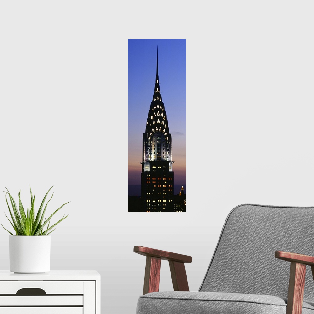 A modern room featuring Vertical, oversized photograph of the top of the Chrysler Building in New York City, lit up again...