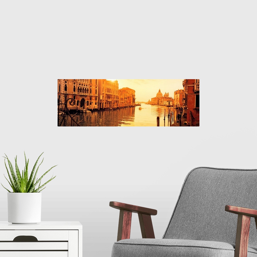 A modern room featuring This panoramic photograph captures a still moment in the canals at sunset and this historic city ...