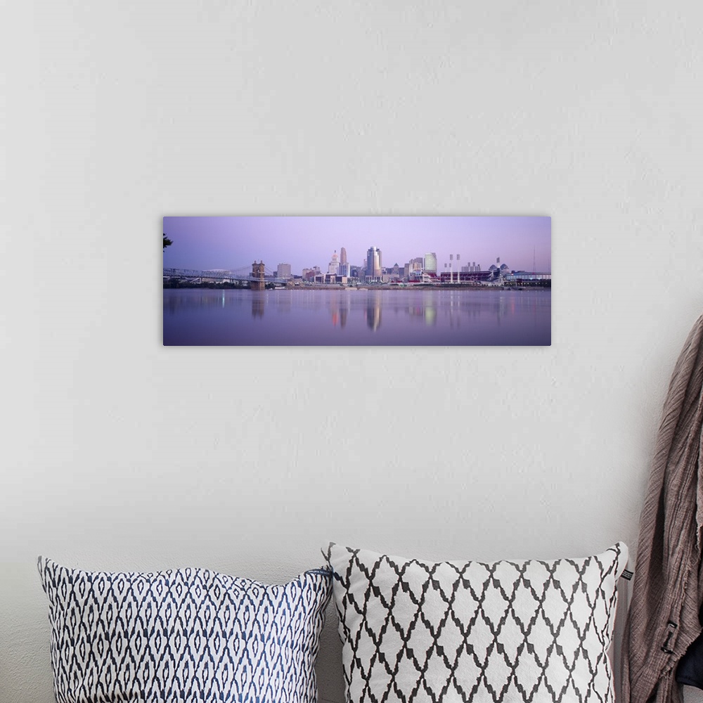A bohemian room featuring A wide angle photograph is taken from across the river of the skyline in Cincinnati during the ev...
