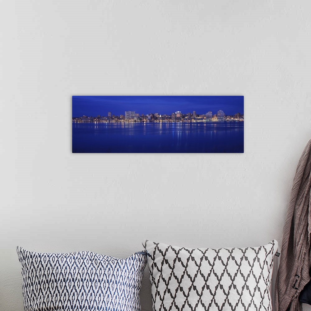 A bohemian room featuring Large panoramic print of buildings lit up along a water front at night in Canada.