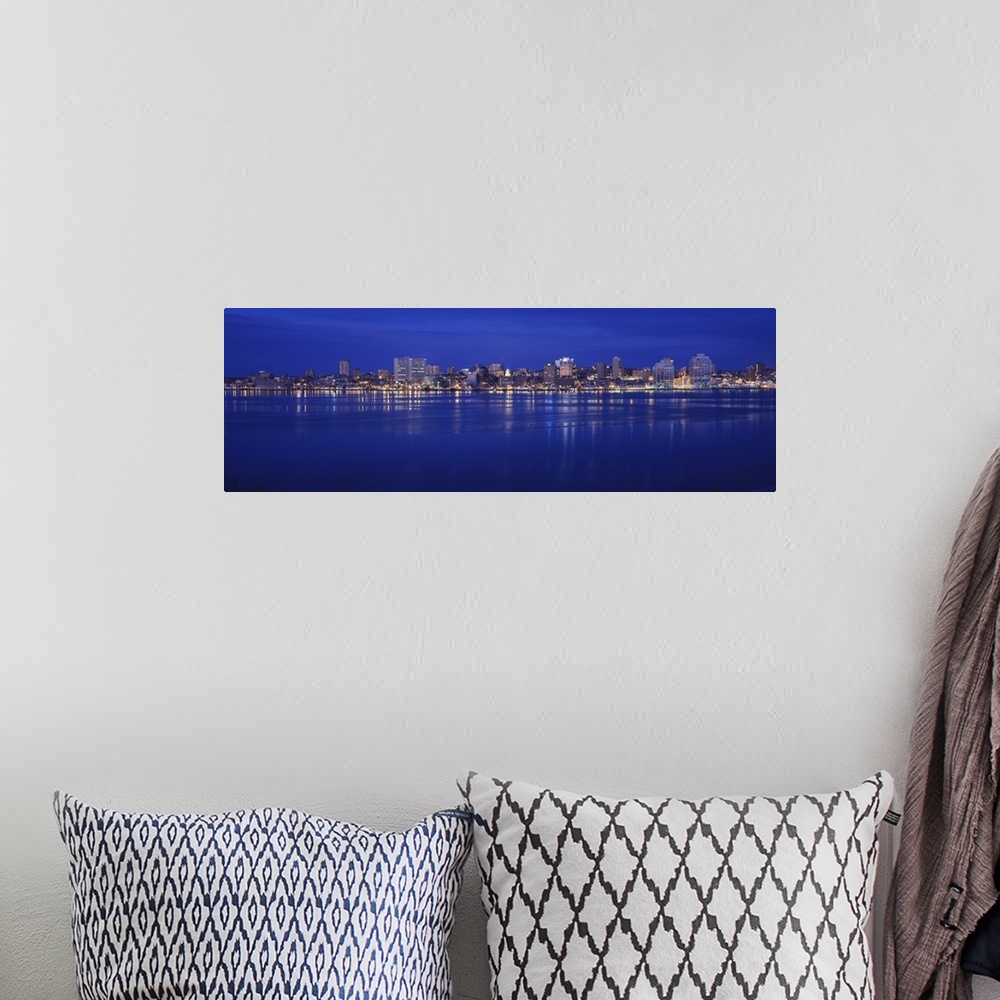 A bohemian room featuring Large panoramic print of buildings lit up along a water front at night in Canada.