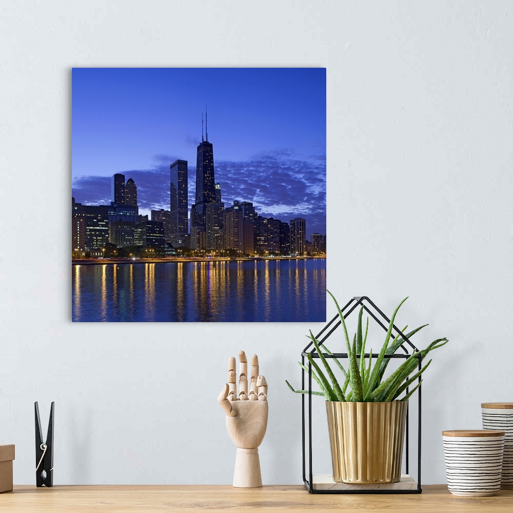 A bohemian room featuring Big, square photograph of the Chicago skyline at night, reflecting in the waters of Lake Michigan.