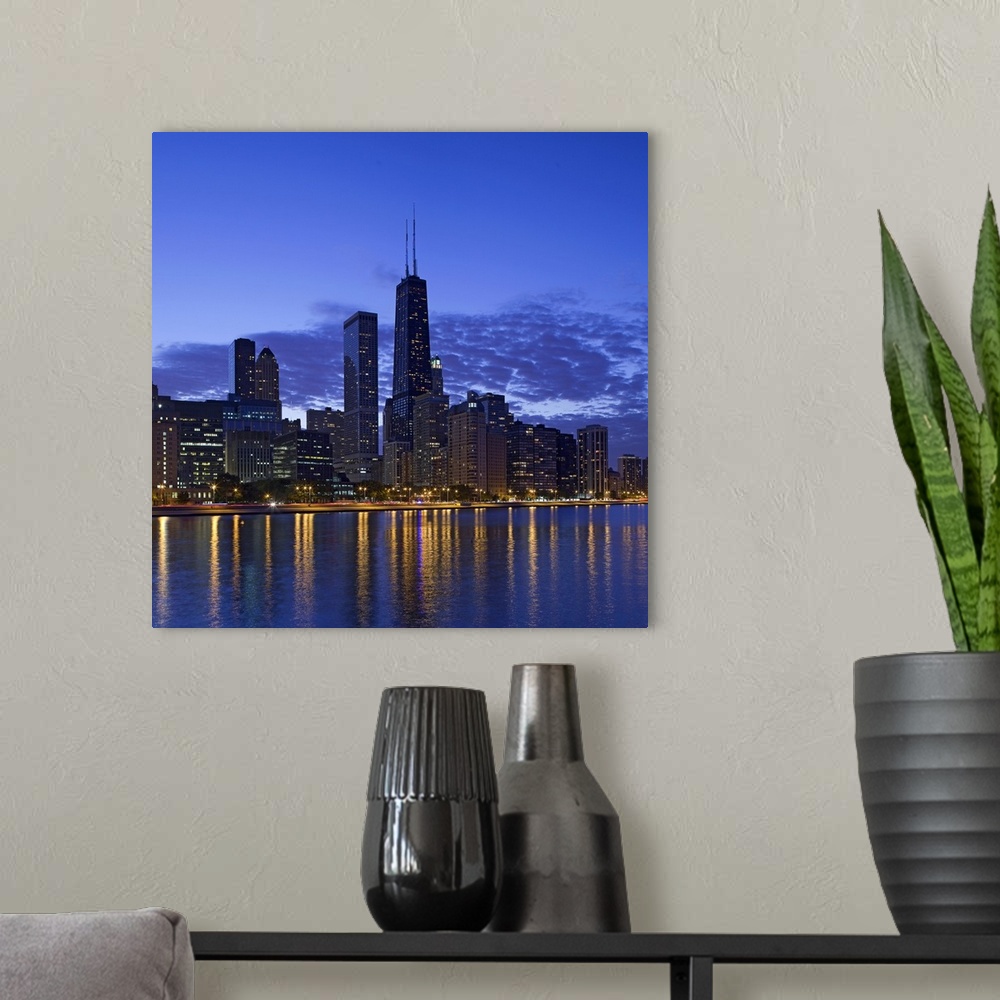 A modern room featuring Big, square photograph of the Chicago skyline at night, reflecting in the waters of Lake Michigan.
