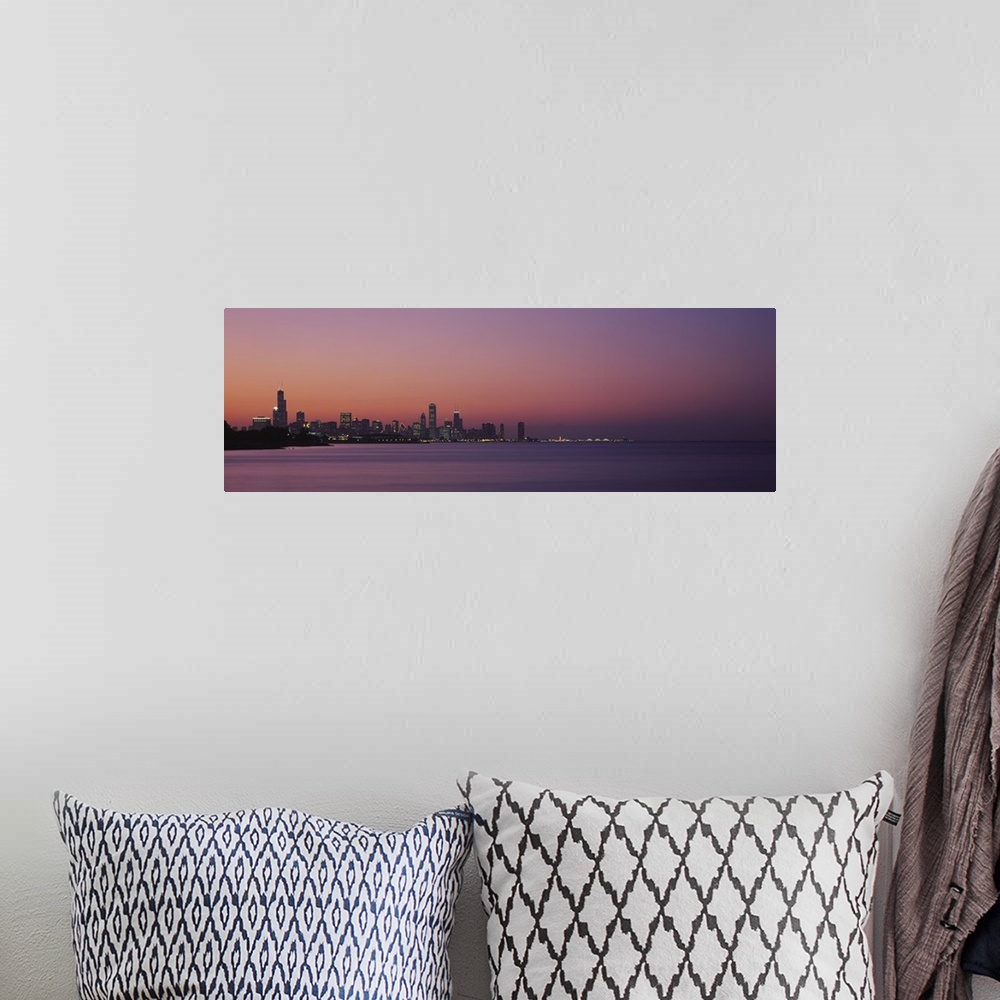 A bohemian room featuring The Chicago skyline is skewed to the left of this panoramic piece and silhouetted by a sunset sky...