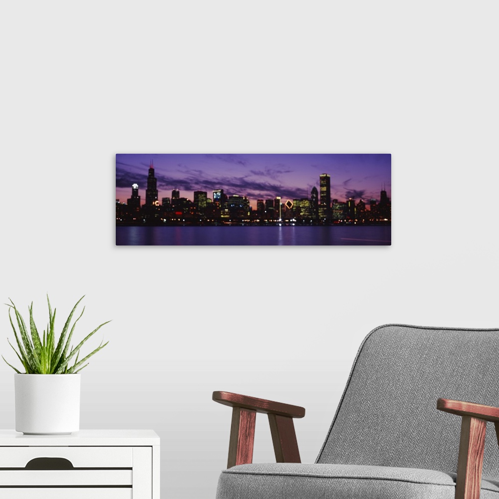 A modern room featuring Wide angle view of the Chicago skyline lit beneath a vibrant night sky, over the waters of Lake M...
