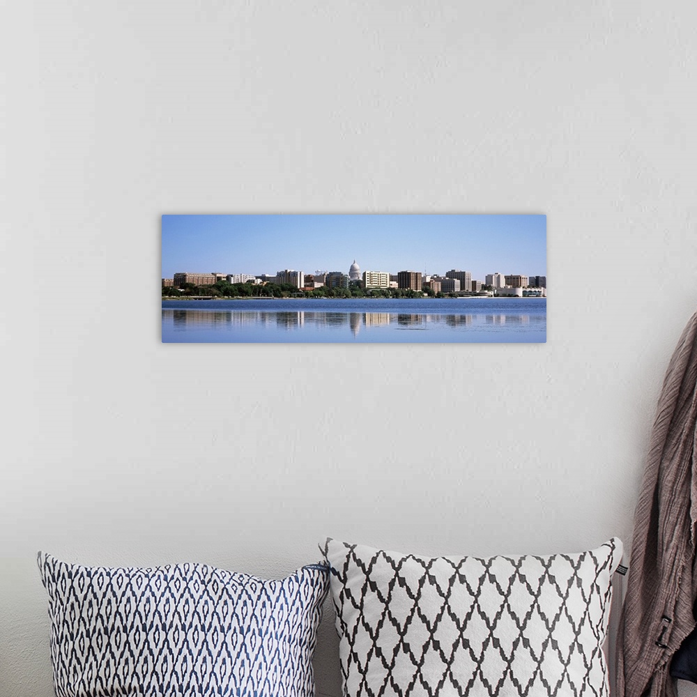 A bohemian room featuring Panoramic picture taken of the city skyline in the capitol of Wisconsin. There is a body of water...