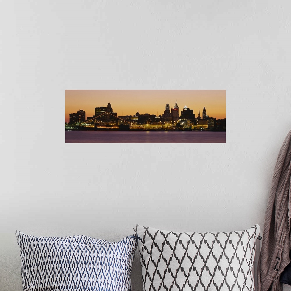 A bohemian room featuring Wide angle photograph of the Philadelphia skyline, lit up at night.