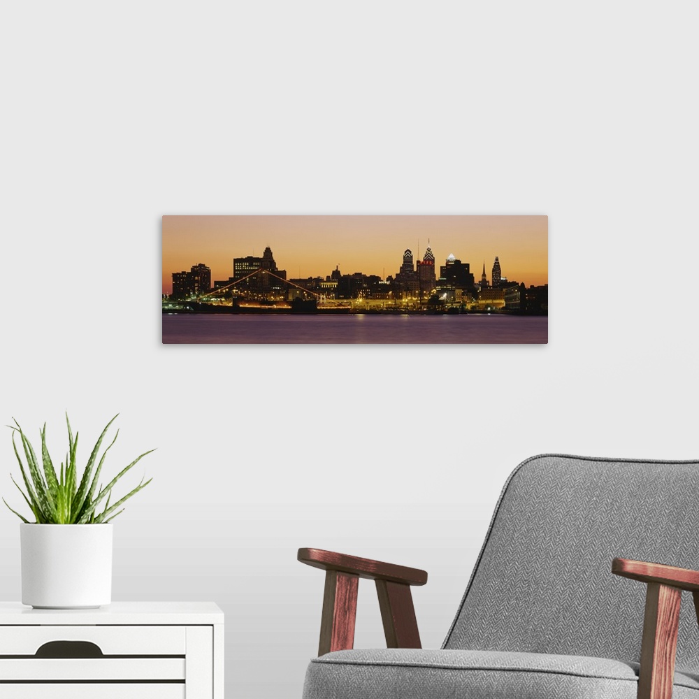 A modern room featuring Wide angle photograph of the Philadelphia skyline, lit up at night.
