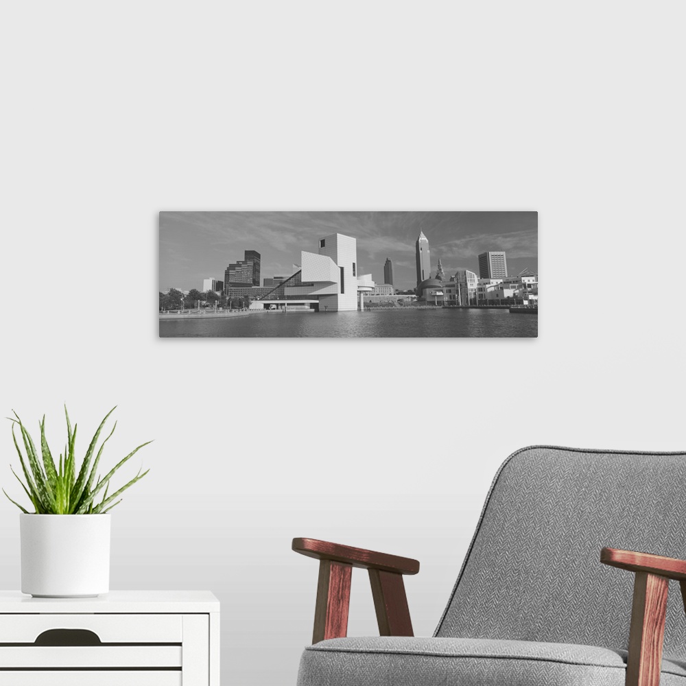A modern room featuring A black and white panoramic photograph taken of buildings in Cleveland sitting on water with the ...