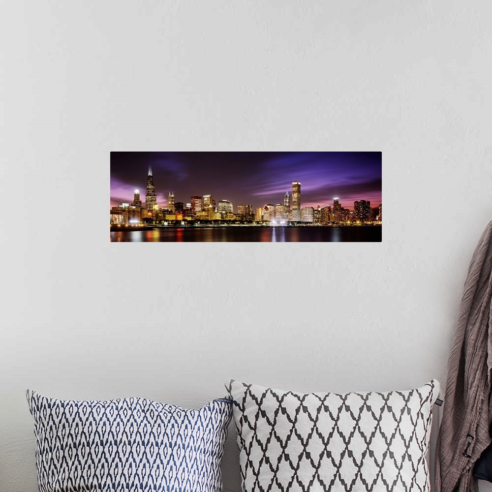 A bohemian room featuring A big cityscape panoramic of downtown Chicagoos lights reflecting off Lake Michigan at night.