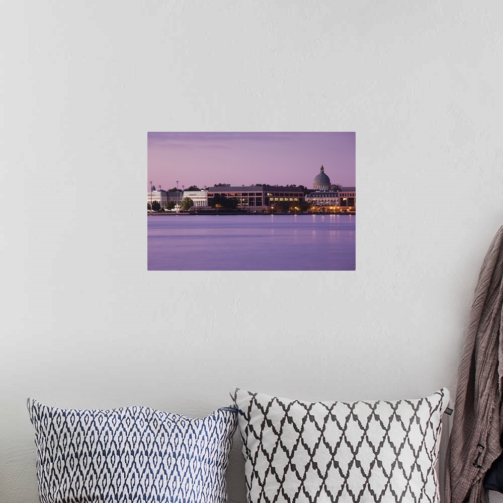 A bohemian room featuring Wall art of the US Naval Academy building on the waterfront at dusk.