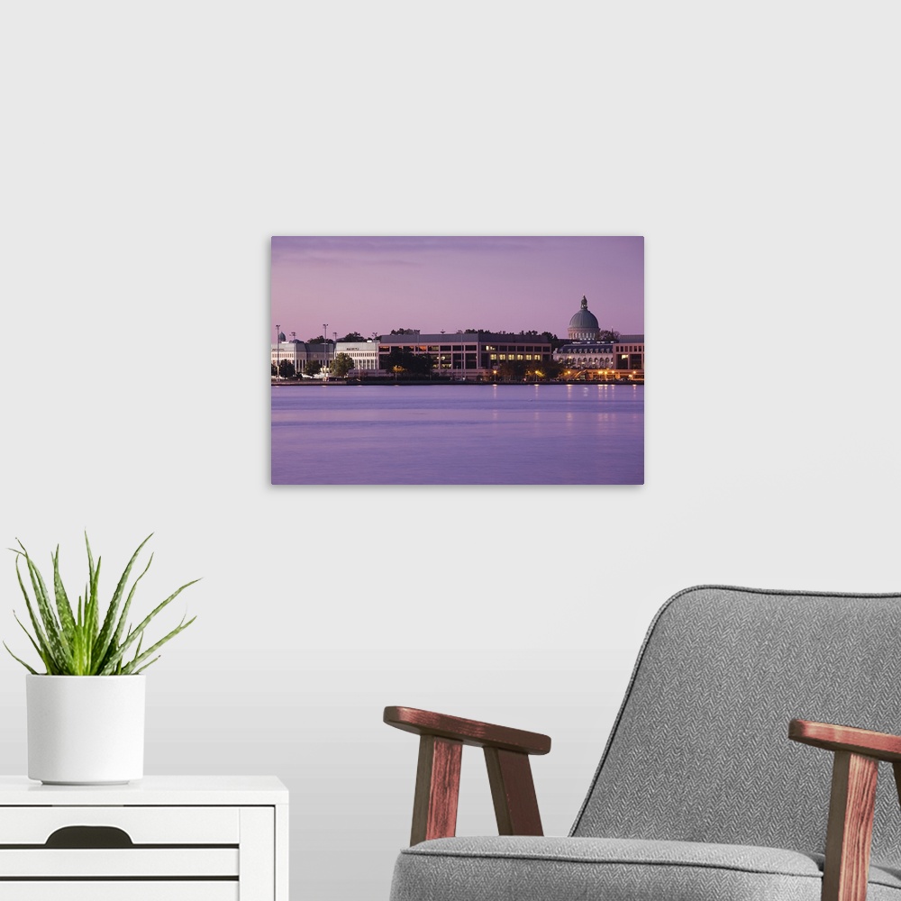 A modern room featuring Wall art of the US Naval Academy building on the waterfront at dusk.