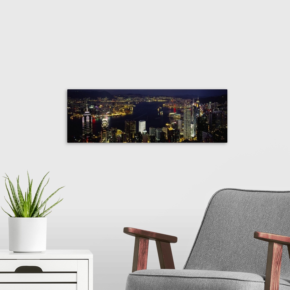 A modern room featuring Panoramic photograph shows a nighttime aerial view overlooking a busy city-state that is enclosed...
