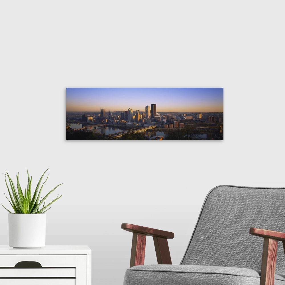A modern room featuring Panoramic photograph of skyline and water front at dusk.