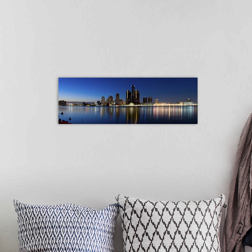 A bohemian room featuring Narrow canvas print of the Detroit skyline illuminated in the evening with it's lights reflecting...