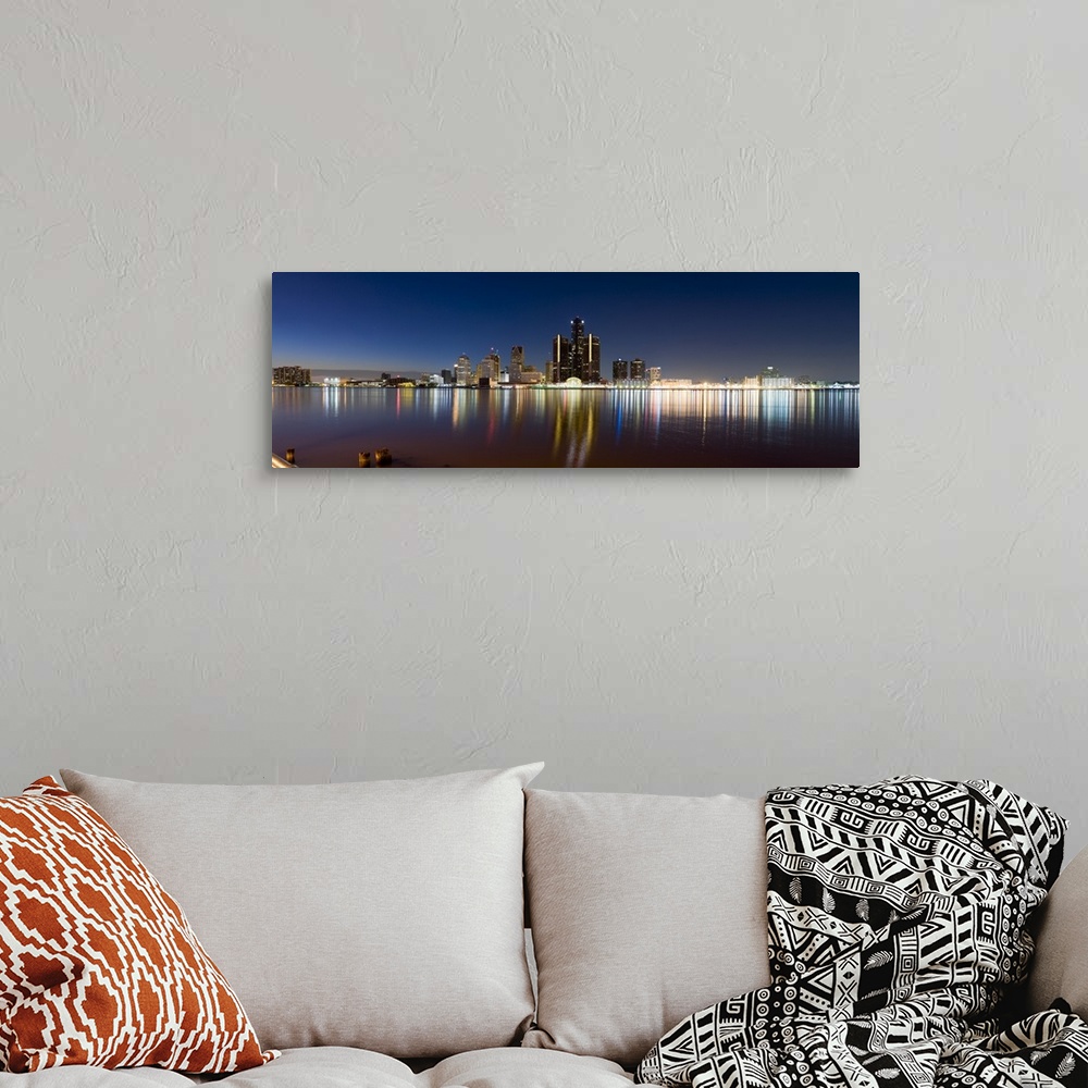 A bohemian room featuring Panoramic photograph of skyline and waterfront at night.  The building lights create colorful ref...
