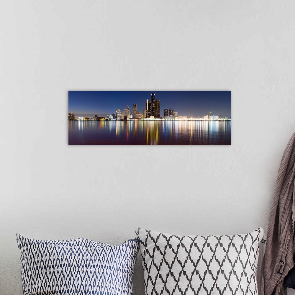 A bohemian room featuring Wide angle photograph of the distant Detroit skyline, lit at night and reflecting in the waters o...