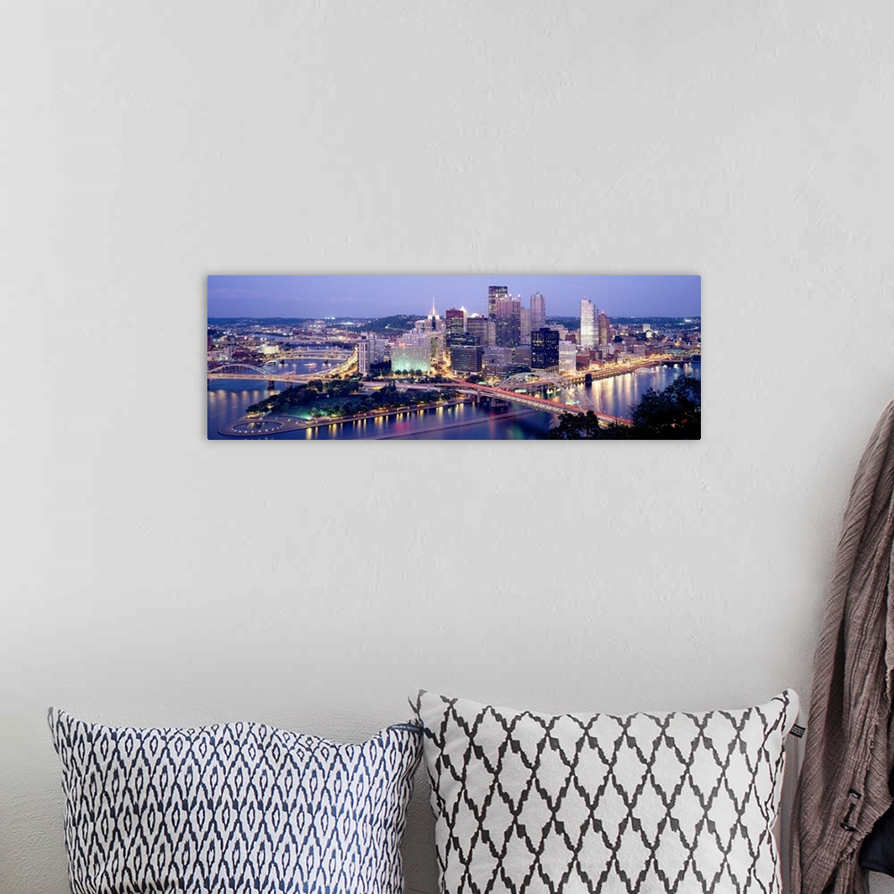 A bohemian room featuring Panoramic canvas of a cityscape by a river with bridges spanning across it at dusk.