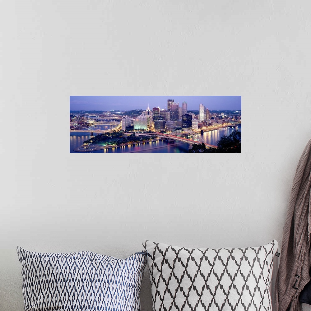A bohemian room featuring Panoramic canvas of a cityscape by a river with bridges spanning across it at dusk.