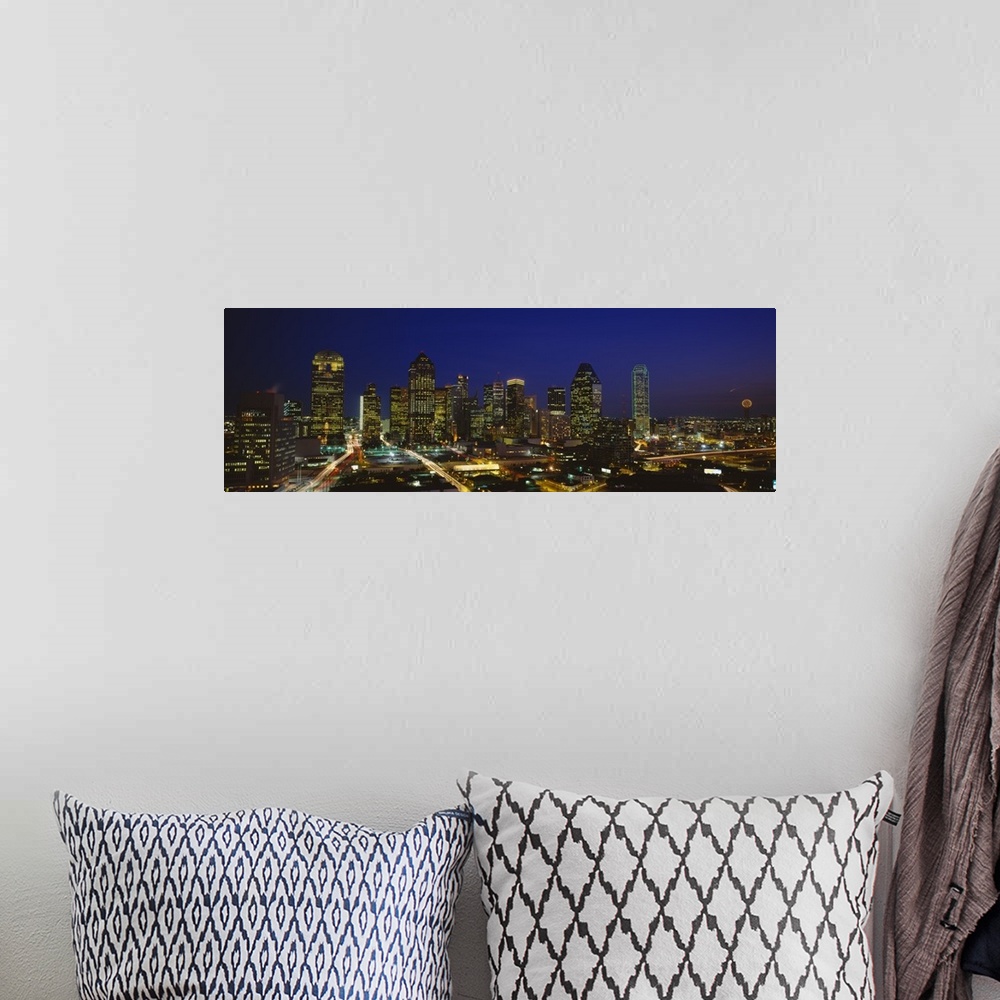 A bohemian room featuring Panoramic photograph showcases the busy skyline of Dallas, Texas as it shines at night.