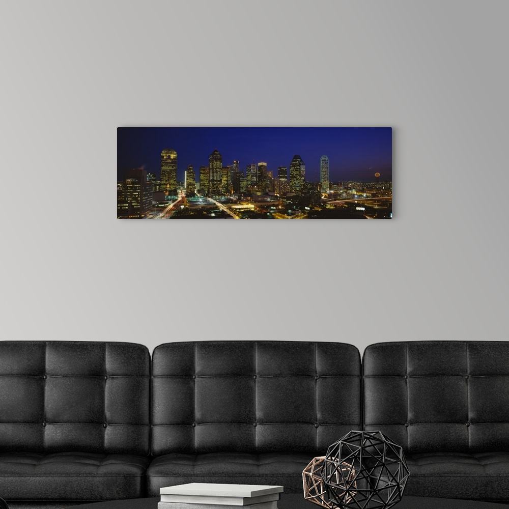 A modern room featuring Panoramic photograph showcases the busy skyline of Dallas, Texas as it shines at night.