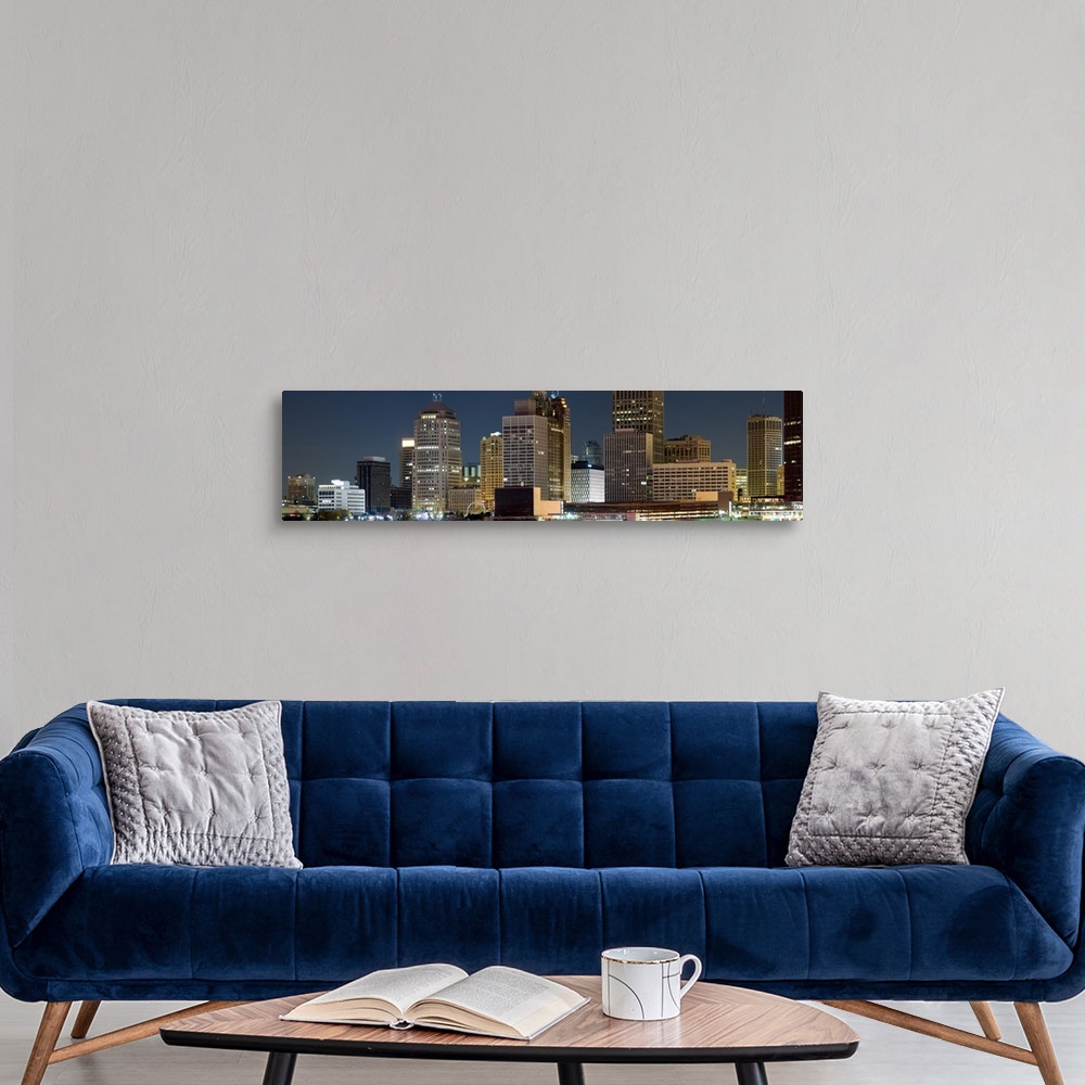 A modern room featuring Oversize horizontal photograph of lit skyscrapers against a deep blue sky at night, in Detroit, M...