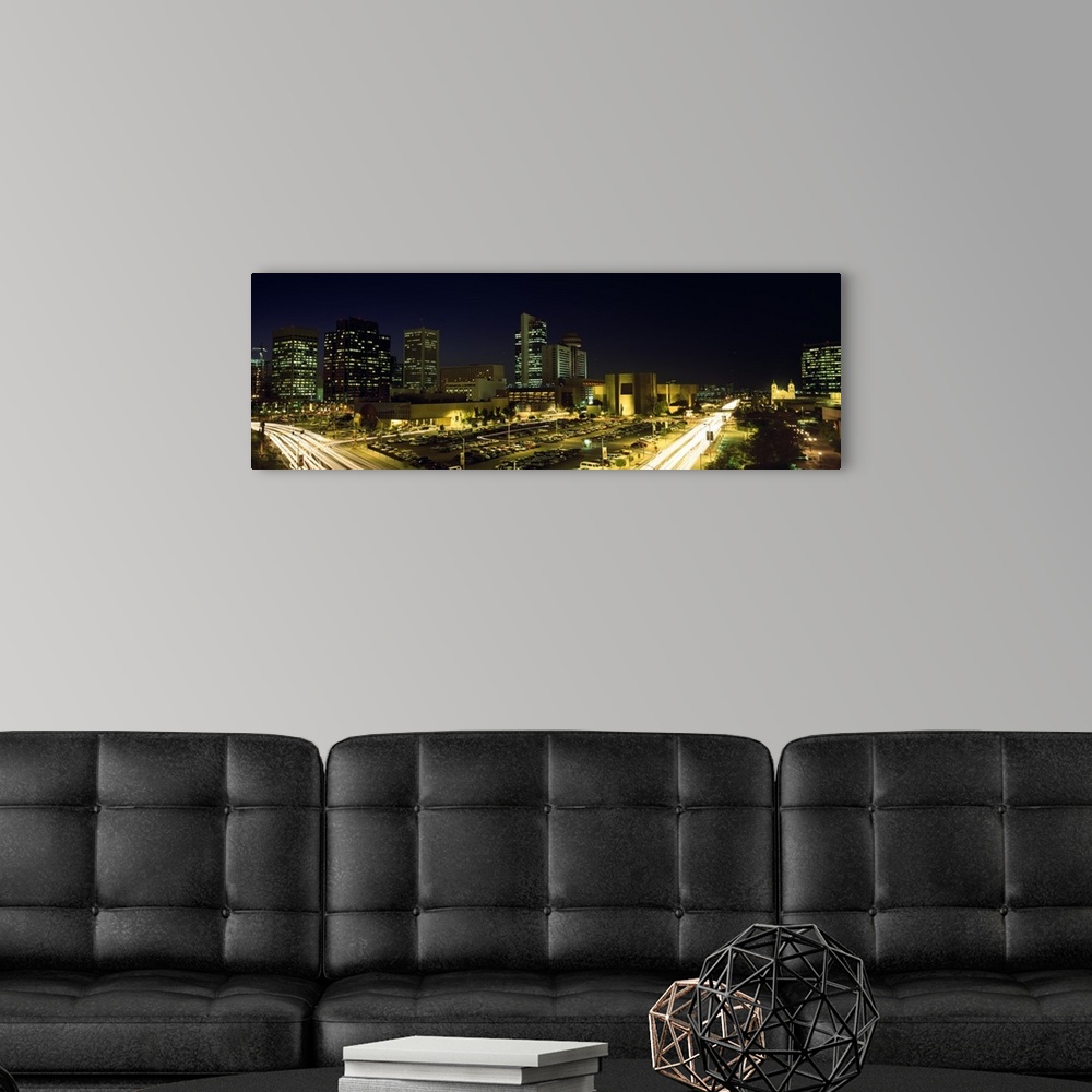 A modern room featuring Panoramic canvas of buildings in Phoenix illuminated at night.