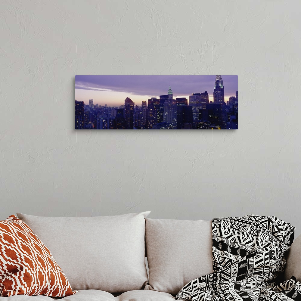 A bohemian room featuring A wide angle shot taken of the Manhattan skyline with the buildings lit up at night with a view o...