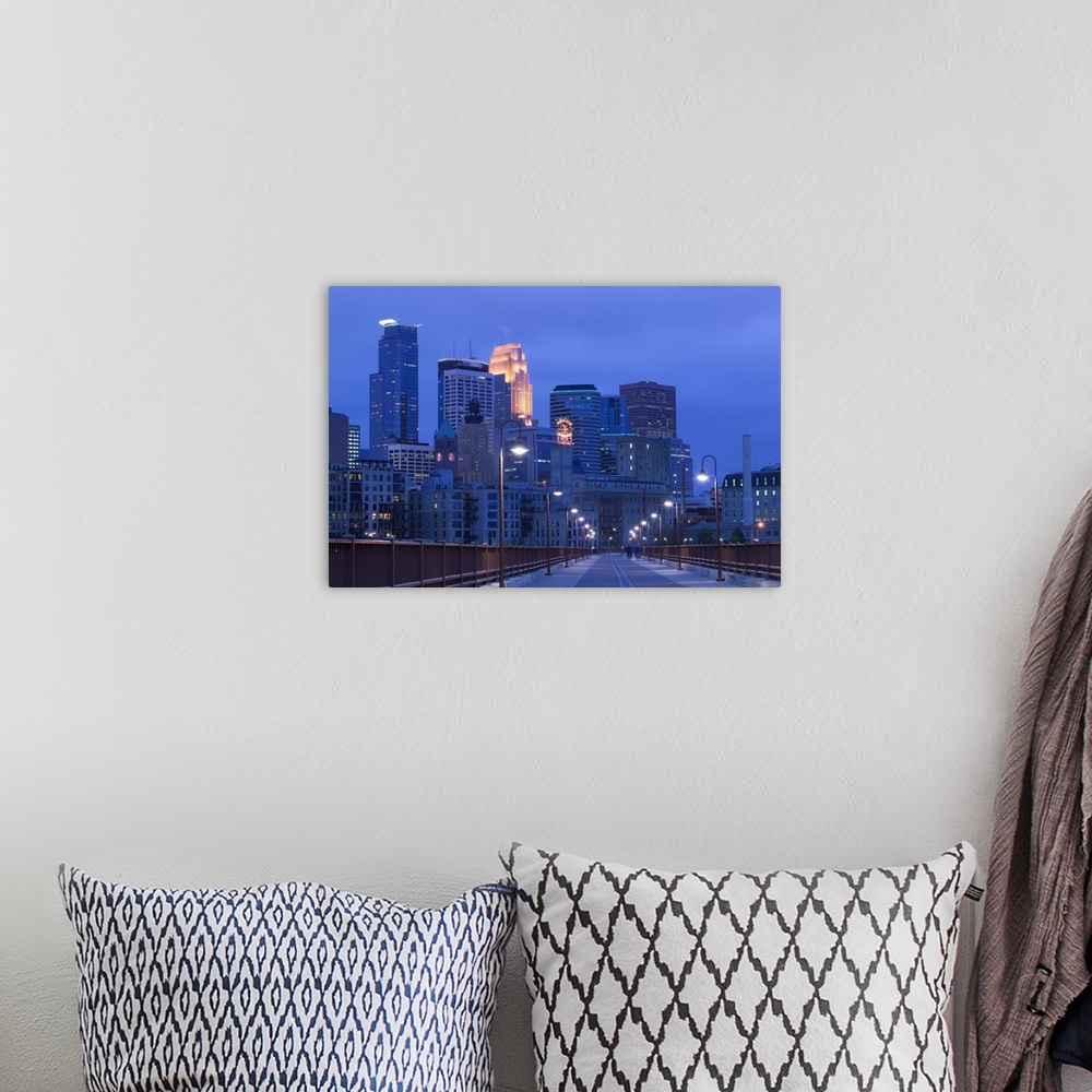 A bohemian room featuring Giant photograph taken of skyscrapers filling the Minneapolis skyline at night.  The light posts ...